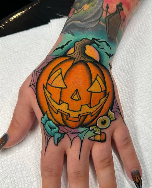 Medium Neo Traditional Jack o lantern with Spiderweb Halloween Tattoo on Women Hand by @jennmanselltattoo