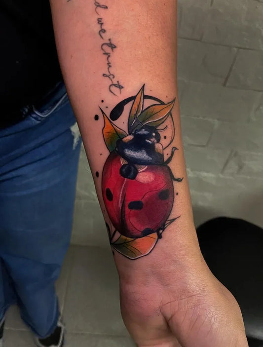 Medium Neo Traditional Ladybug and Leaves Tattoo on Women Wrist by @fernaink