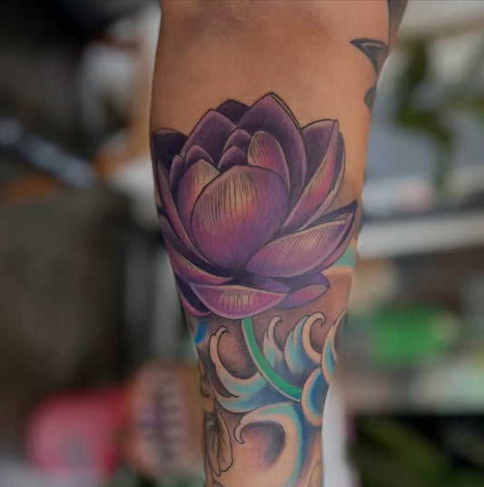 Medium Neo Traditional Lotus Flower with Waves on Women Leg Tattoo by @tattoonouvelle