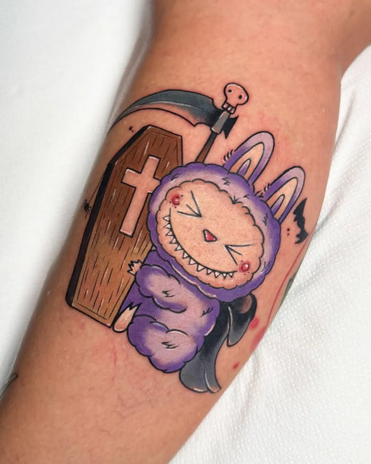 Medium Neo Traditional Purple Bunny with Coffin and Scythe Halloween Tattoo on Women Arm by @itscrizti.tattoo