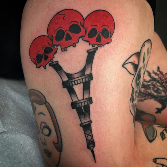 Medium Neo Traditional Red Skulls Eiffel Tower Tattoo on Women Arm by @kenzie.lara.tattoos