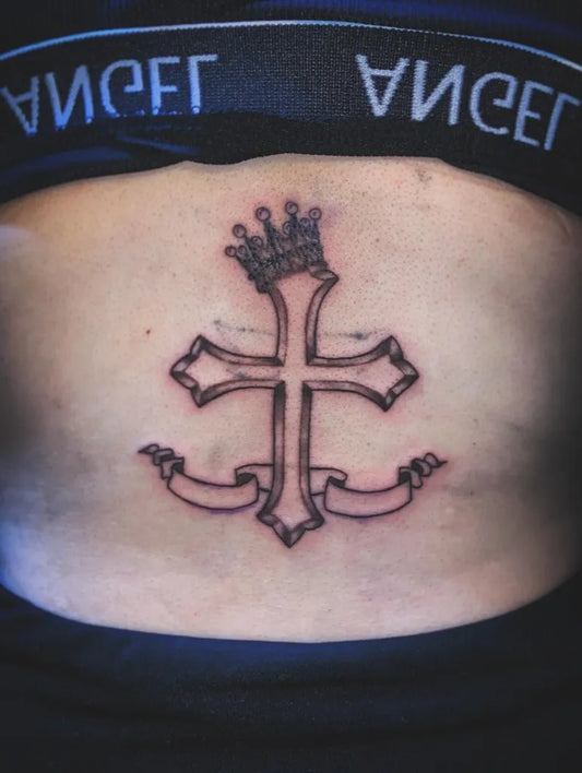 Medium Neotraditional Crowned Cross with Ribbons on Women Back Tattoo by @kid__tattooer