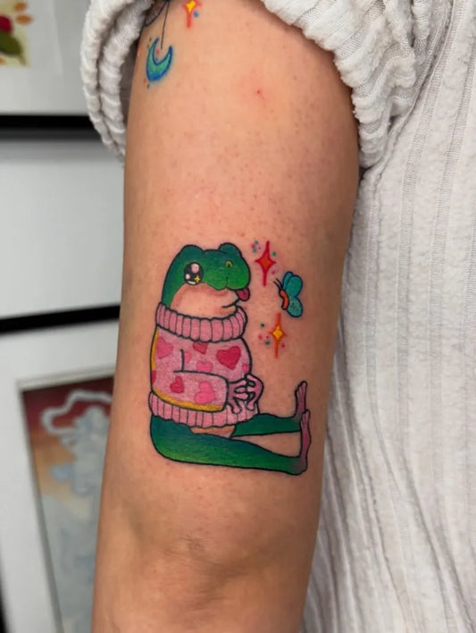 Medium Neotraditional Frog in Sweater Tattoo on Women Arm by @foxx.teeth_