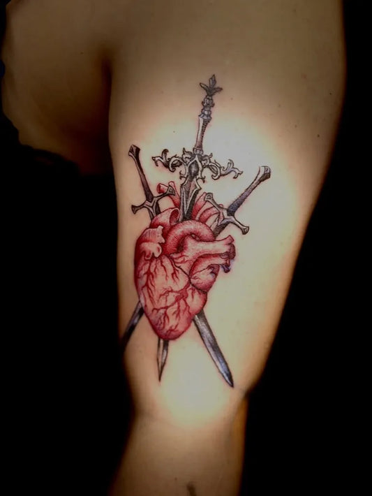 Medium Neotraditional Heart pierced by @three swords on Women Upper Arm Tattoo by @honeyblisstattoos