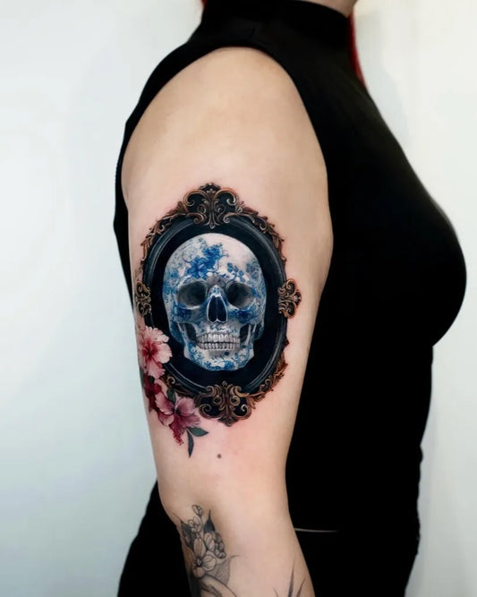Medium Neotraditional Skull in Frame with Flowers on Women Arm Tattoo by @chou_tatt
