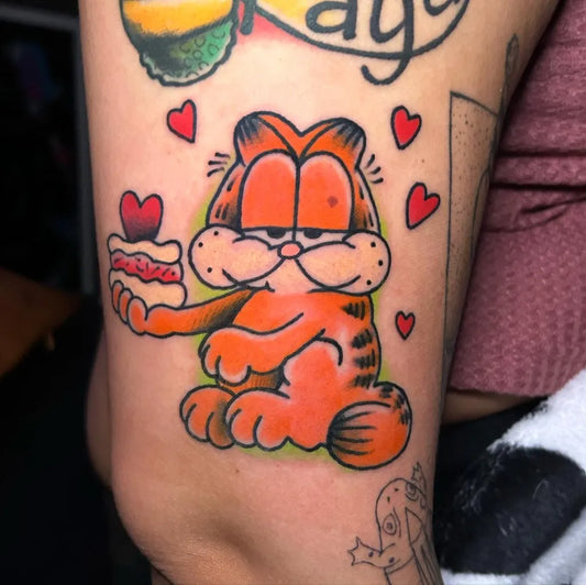 Medium New School Garfield with Cake and Hearts Cartoon Tattoo on Women Arm by @charlld0