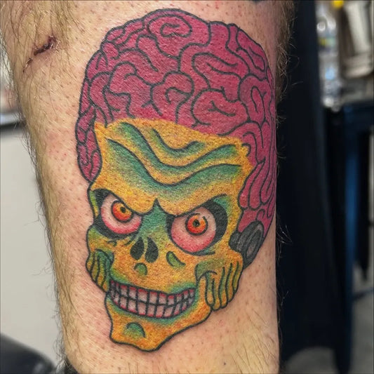 Medium New School Green Skull with Red Hair Halloween Tattoo on Men Arm by @dannytattooer