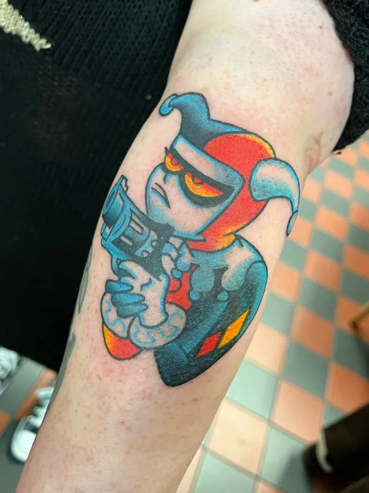 Medium New School Joker with Gun on Women Arm Tattoo by @lennyflashtattoo