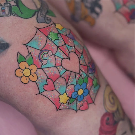 Medium New School Rainbow Web Hearts Tattoo on Women Knee by @darciekaportattoo