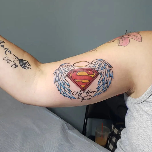 Medium New School Superman LOGO Shield with Angel Wings and Mother Friend Text Tattoo on Women Bicep by @kandikotton