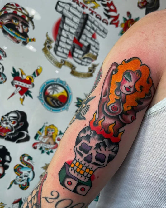 Medium Old School Pin Up Girl with Skull and Flames Tattoo on Women Arm by @mikemillertattoos