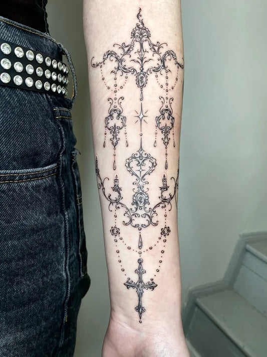 Medium Ornamental Cross Chandelier Tattoo on Women Arm by @nightmar.y