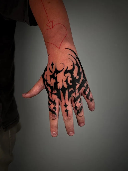 Medium Ornamental Tribal Heart Tattoo on Men Hand by @iroh.topia