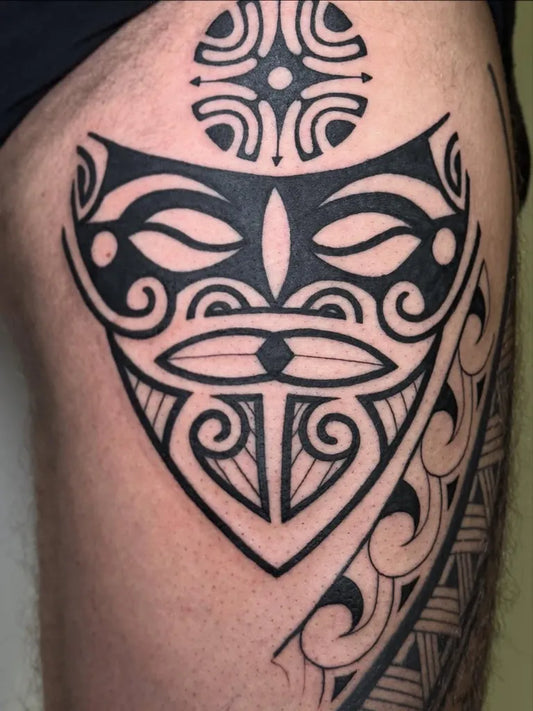 Medium Polynesian Mask Tattoo on Men Thigh by @moon_rabbit_tattoo