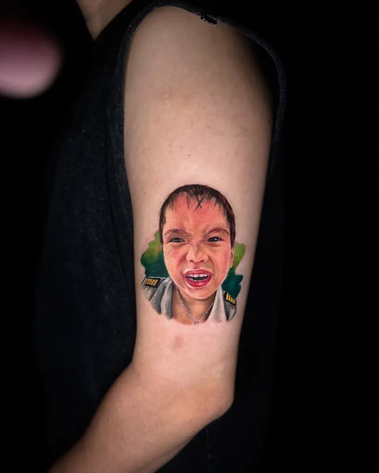 Medium Portrait Boy with Green Leaves on Women Arm Tattoo by @mr_inker_
