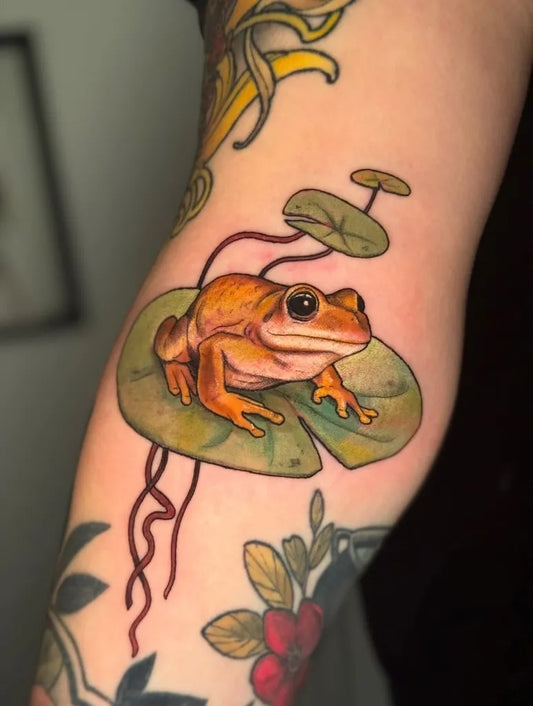 Medium Realism Frog on Lily Pad Tattoo on Women Arm by @daughterofmars.tattoos