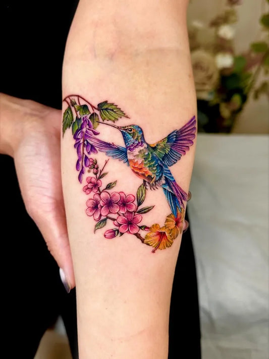 Medium Realism Hummingbird Flowers on Women Arm Tattoo by @claire_tattoos_