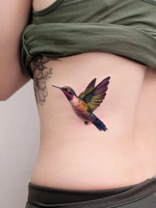 Medium Realism Hummingbird on Women Side Tattoo by @pokhy_tattoo