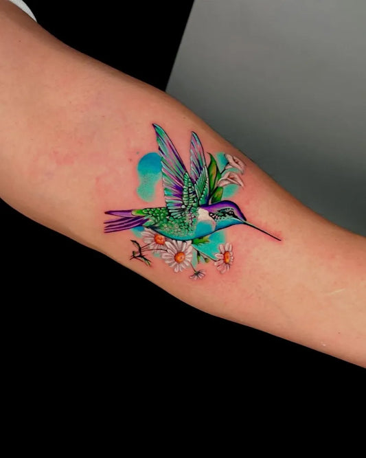 Medium Realism Hummingbird with Flowers and Leaves on Women Arm Tattoo by @claudiogajardo.art