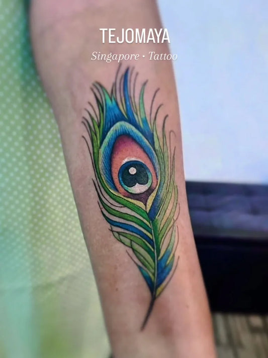 Medium Realism Peacock Feather Tattoo on Women Arm by @tejomaya.tattoostudio