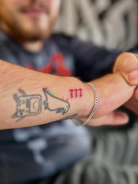 Medium Red 777 Tattoo on Men Arm by @luzifer.444