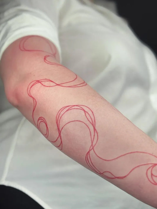 Medium Red Swirling Lines Tattoo on Women Arm by @maggie.garioni