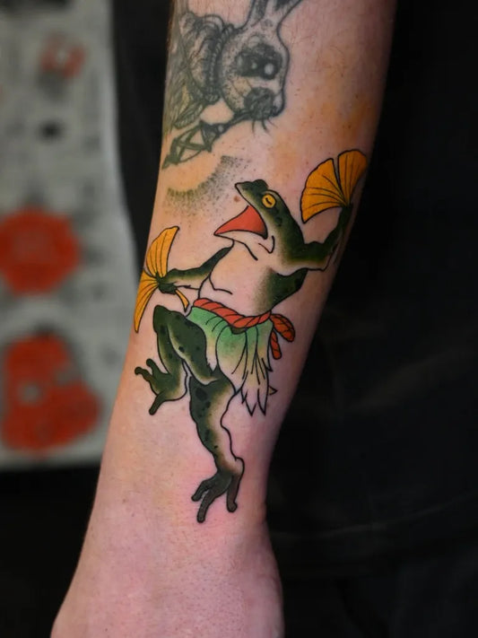 Medium Traditional Frog with Fans Tattoo on Men Arm by @a_u_r.a