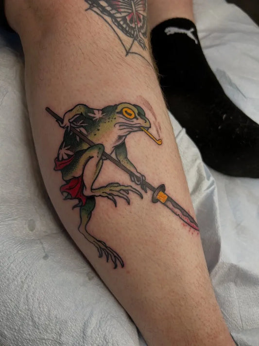 Medium Traditional Frog with Sword Tattoo on Men Leg by @karlb_tattoo
