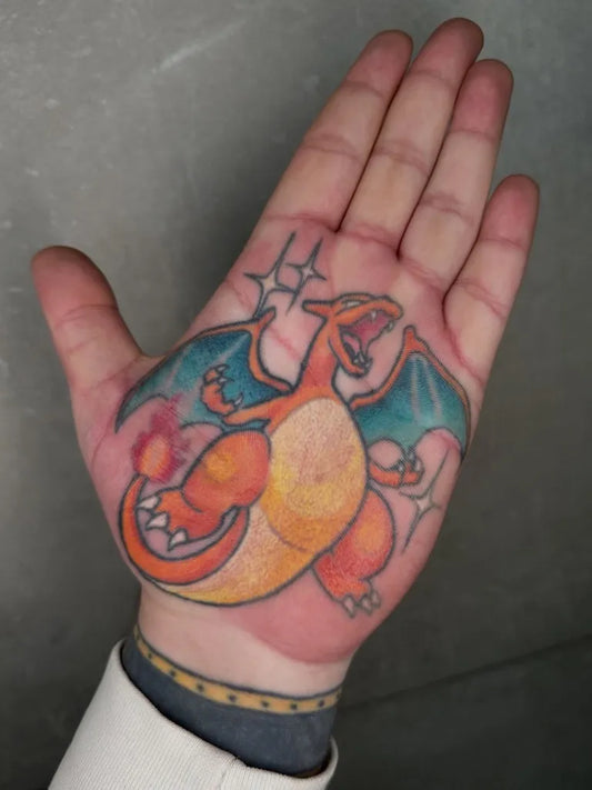 Medium Traditional Pokemon Charizard Tattoo on Men Hand by @lukeaashley