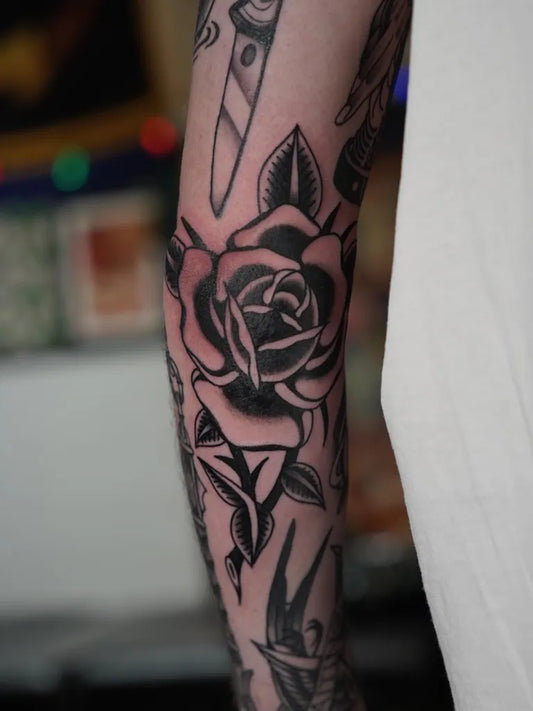 Medium Traditional Rose and Dagger Tattoo on Men Arm by @joana.tattooer