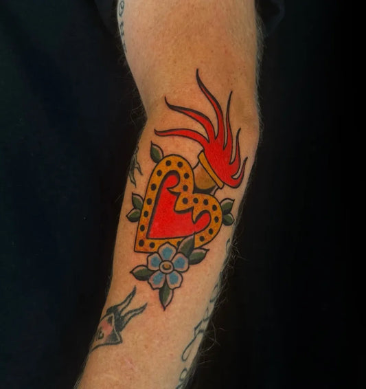 Medium Traditional Sacred Heart with Flames and Flower Tattoo on Men Arm by @izzmink