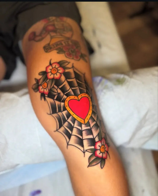Medium Traditional Web and Heart Tattoo on Women Knee by @lindenstreettattooco