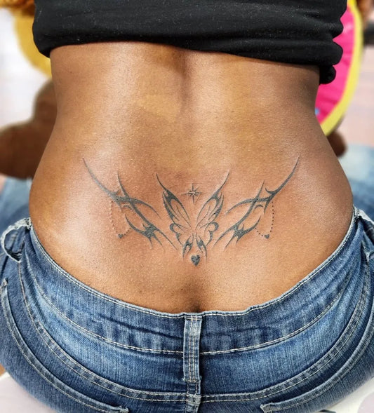 Medium Tribal Butterfly Tattoo on Women Lower Back by @inkgarage_brooklyn