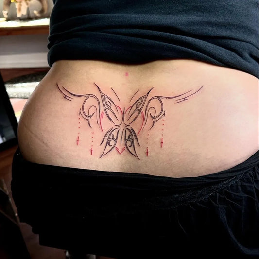 Medium Tribal Butterfly Tattoo on Women Lower Back by @tomharrilltattoos