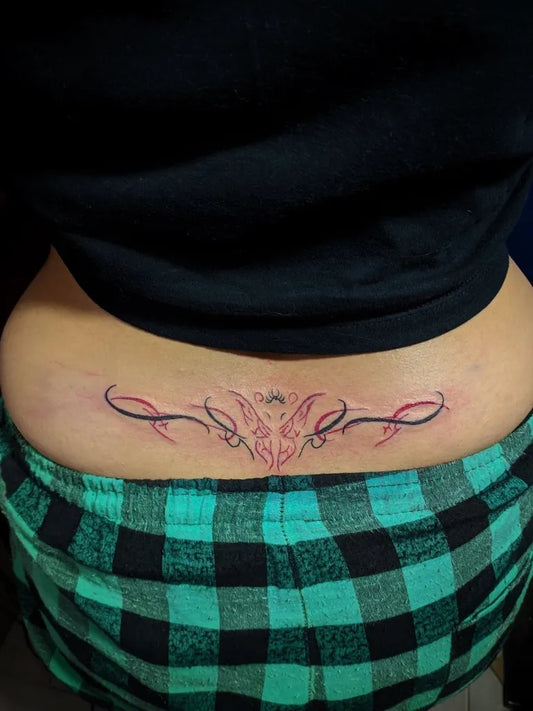 Medium Tribal Butterfly Tattoo on Women Lower Back by @zetta.tattoo