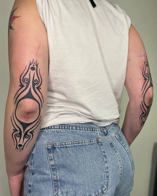 Medium Tribal Eyes and Spirals Tattoo on Men Elbow by @ashley_thorne_tattoo