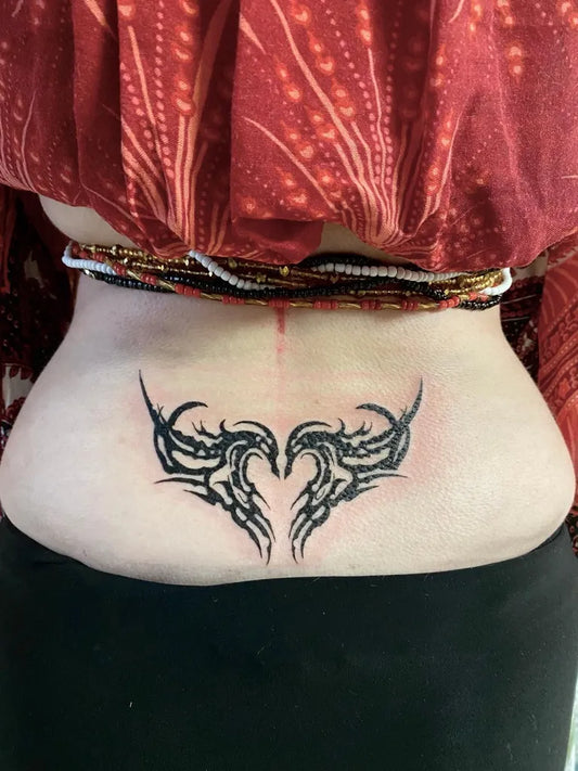 Medium Tribal Heart Wings Tattoo on Women Lower Back by @_heshin_