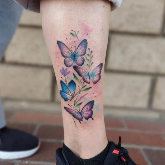 Medium Watercolor Butterflies and Flowers Tattoo on Women Calf by @mr.inkwells