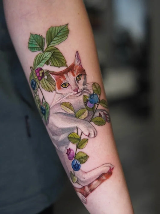 Medium Watercolor Cat with Berries and Leaves Tattoo on Women Arm by @kotyns