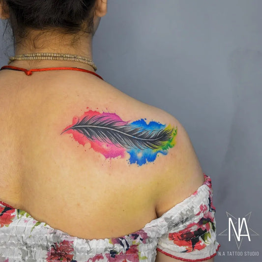 Medium Watercolor Feather Tattoo on Women Shoulder by @natattoostudio
