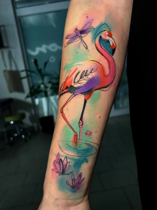 Medium Watercolor Flamingo Dragonfly Lotus Tattoo on Women Arm by @lenalejskova_tattooer