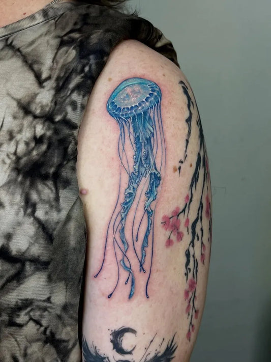 Medium Watercolor Jellyfish and Cherry Blossoms Tattoo on Women Shoulder by @oceanide.tattoo.artist