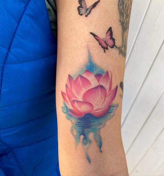 Medium Watercolor Lotus Flower Butterflies on Women Arm Tattoo by @thebreakroomtattoo
