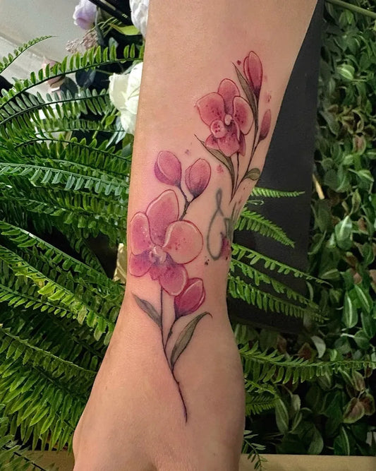 Medium Watercolor Orchid and Fern Tattoo on Women Arm by @faith.tattoo