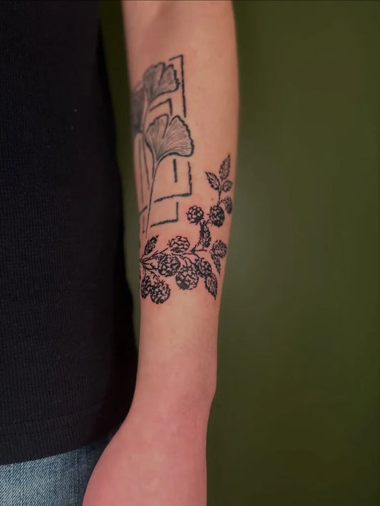 Medium Woodcut Ginkgo Leaf and Blackberry Branch Tattoo on Women Arm by @tapiotats