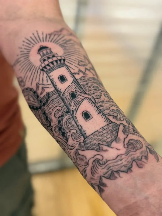 Medium Woodcut Lighthouse with Waves and Rays Tattoo on Men Arm by @alyssamayart