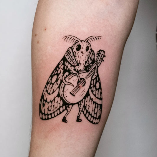 Medium Woodcut Moth Playing Guitar Tattoo on Women Arm by @ola.krupnik