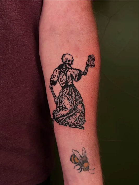 Medium Woodcut Skeleton Woman with Beer Mug and Bee Tattoo on Men Arm by @tapiotats