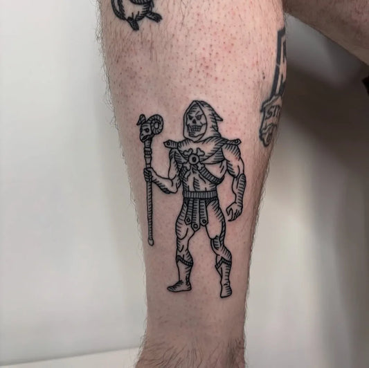 Medium Woodcut Skeletor with Staff Tattoo on Men Leg by @train.wrex