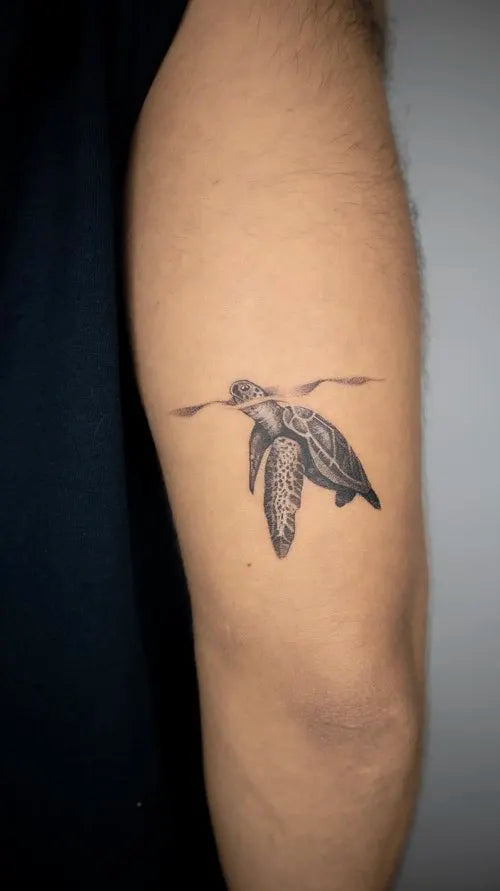 realistic sea turtle tattoo on upper arm